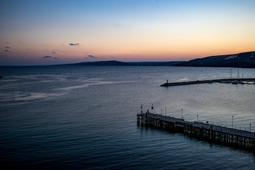 Fototapeta na wymiar High view seascape towards Black Sea from the last story of the mill near the port at Balchik, Bulgaria, the blue hour right after sunset. Beautiful autumn landscape.