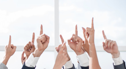 group of young businessmen standing in a circle and pointing up
