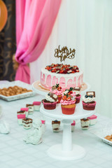 white stand with cupcakes on a candy bar table