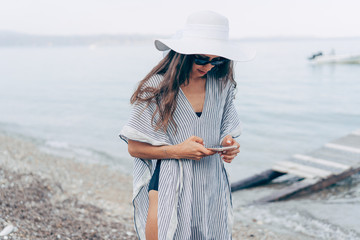 Attractive woman is standing in the water with a phone