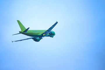 takeoff of a green passenger liner against a blue sky, toned