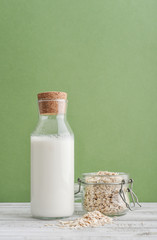 Bottle of  oat milk with oat flakes