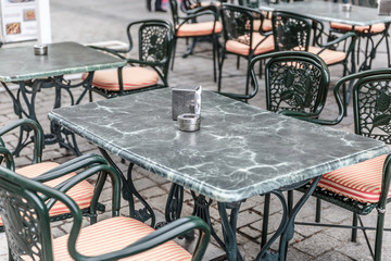 Typical tables and chairs outside a bar in Madrid, with napkins and ashtray