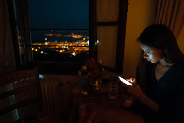 Woman using smart phone for online at home in evening