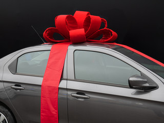 gray car with red ribbon on black