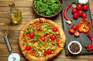 pizza on wood table with ingredients