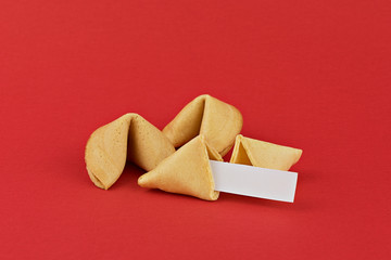 Traditional Chinese new year fortune cookies on red background with white paper for mottos