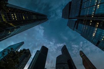 bottom-up view of skyscrapers and flying clouds