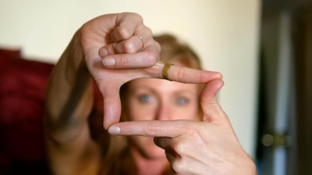 Womans hands coming into focus framing a shot. 