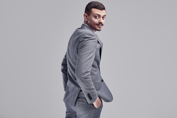 Handsome young arabic businessman with mustache in fashion gray suit