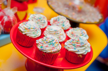 cup cakes, packaged in red and covered with colored confectionery