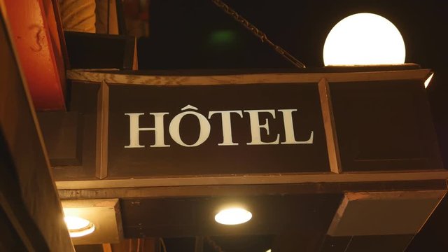 Hotel sign in Ville de Quebec, Quebec, Canada. Insects flying around lights.