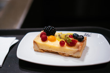 On the table is a plate with cheesecake.