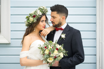 young couple bride groom getting married wedding posed photos at seaside sea beach hairpiece flowers bouquet church