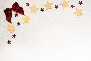 Christmas background, with gold glitter stars, red bow, and snow - sophisticated, luxury - copyspace
