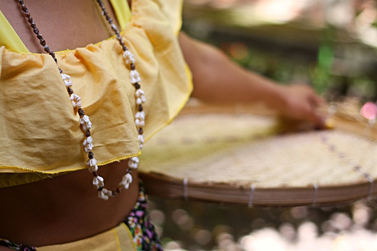 Mulher com vestido t&iacute;pico segurando uma peneira de palha em dan&ccedil;a do folclore do nordeste brasileiro