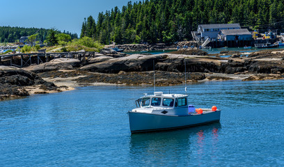 Maine Lobster Boat Anchored in a Bay in Front of a Rocky New England Coast