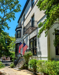 Fototapeta na wymiar Two American Flags Flying on a Historic Street in Savannah Georgia