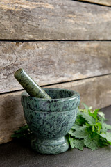 Fresh Valerian Herb Leaves  with Green Marble Mortar and Pestle with rustic wooden background