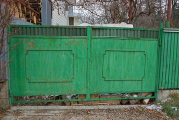 old closed iron green gate on the street