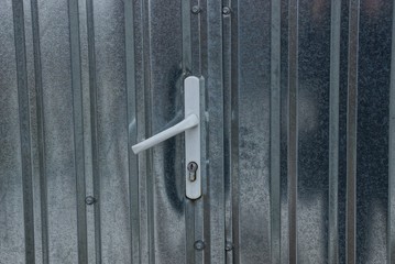 Obraz premium white plastic door handle on a gray metal door