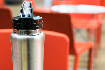Iron thermos with black lid on defocused background