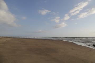Empty sand beach with a clear blue sky, no people
