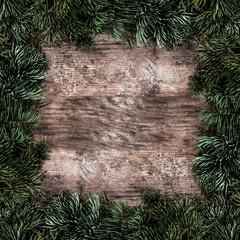 Creative layout frame made of Christmas fir branches on wooden background. Xmas and New Year theme. Flat lay, top view