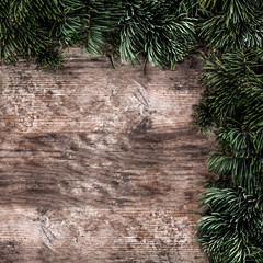 Creative layout frame made of Christmas fir branches on wooden background. Xmas and New Year theme. Flat lay, top view