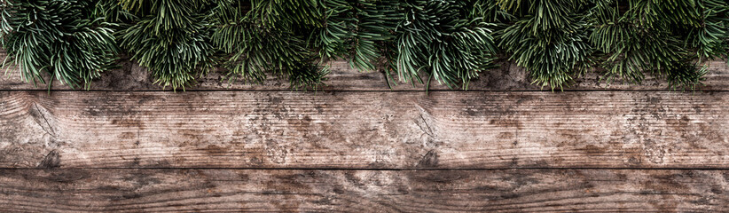 Creative layout frame made of Christmas fir branches, pine cones on wooden background. Xmas and New Year theme. Flat lay, top view, wide composition