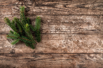 Christmas fir branch on wooden holiday background. Xmas and New Year theme. Flat lay, top view