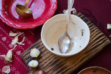 Unclean dirty dishes left after finished food process - breakfast, lunch or dinner. With traces of sauces or pieces of food on surface. Messy kitchenware. Christmas tablecloth. White bowl