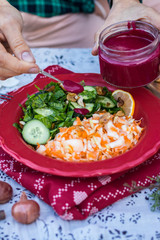 Woman hands adds with spoon red homemade tomato, beetroot sauce dip with peanuts, nuts in jar used for dressing the salads. Vegan vegetarian healthy food
