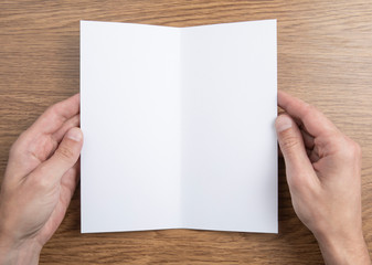 Obraz premium Mens hands holding white booklet