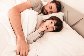 Little Son with Tired Sleeping Father in Bed.