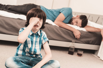 Little Boy Sitting in Room with Drunken Father.