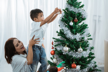 mother and son decorating christmas tree