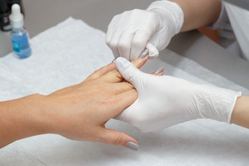 Massage therapist massaging hands of a woman in a beauty salon