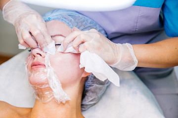 Obraz na płótnie Canvas Young pretty woman enjoying a facial mask procedure