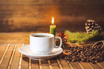 A cup of black coffee with New Year and Christmas attributes.  Christmas  candle. spruce branch.