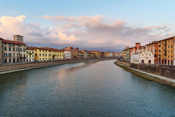 Fototapeta na wymiar View on embankment of Arno river with Church of Santa Maria de la Spina at sunset. Pisa, Italy