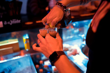 Bartender pouring multicolour alcoholic shots
