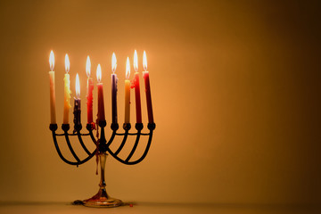 Fototapeta premium Hanukkah menorah with burning colorful candles. Retro old style photo.Copy space for text.