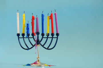  Image of Jewish holiday Hanukkah background with menorah (traditional candelabra) and  colorful candles .Copy space for text.