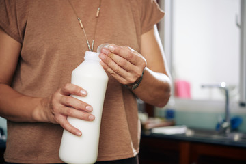 Fototapeta na wymiar Opening milk bottle