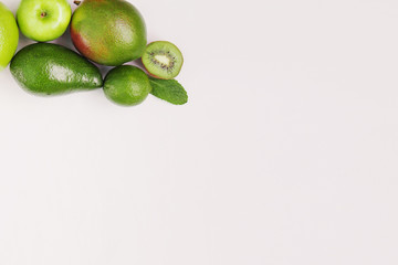 Creative background of green various summer tropical fruits. Food concept for fitness dinner,plant based diet,frutarian,healthy eating