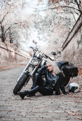 Fototapeta premium Beautiful biker woman posing outdoor with motorcycle. 