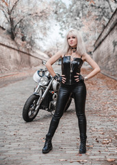 Obraz na płótnie Canvas Beautiful biker woman posing outdoor with motorcycle. 