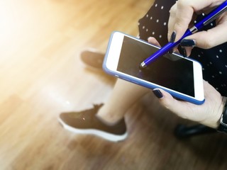 Women using Touch screen stylus on Smartphone.