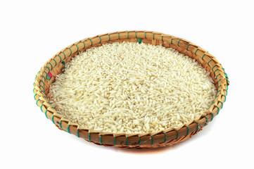 raw rice in bamboo basket isolated / thai sticky white rice on threshing basket